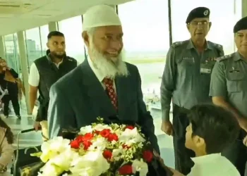 Islamic scholar and public speaker Dr Zaik Naik is greeted with a bouquet of flowers upon his arrival at the Islamabad airport on September 30, 2024.