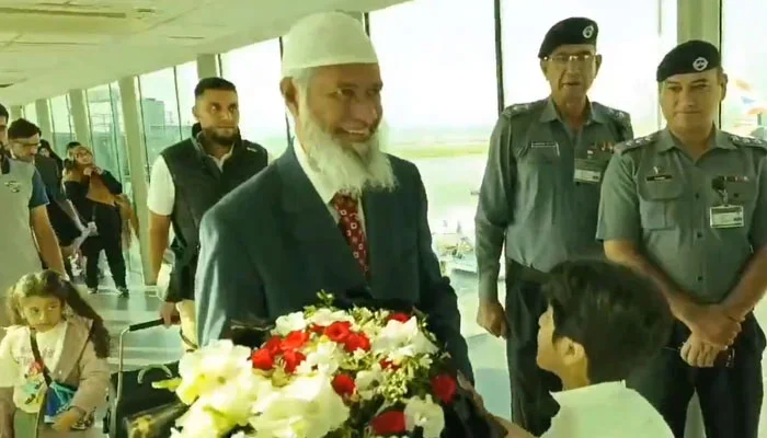 Islamic scholar and public speaker Dr Zaik Naik is greeted with a bouquet of flowers upon his arrival at the Islamabad airport on September 30, 2024.