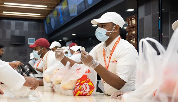 In this undated photo, salesmen are dealing with customers at an outlet of Al Baik Food System Company.
